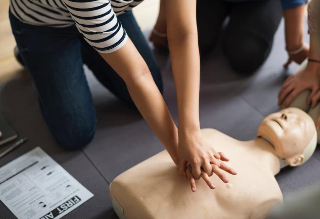 woman doing CPR on mannequin